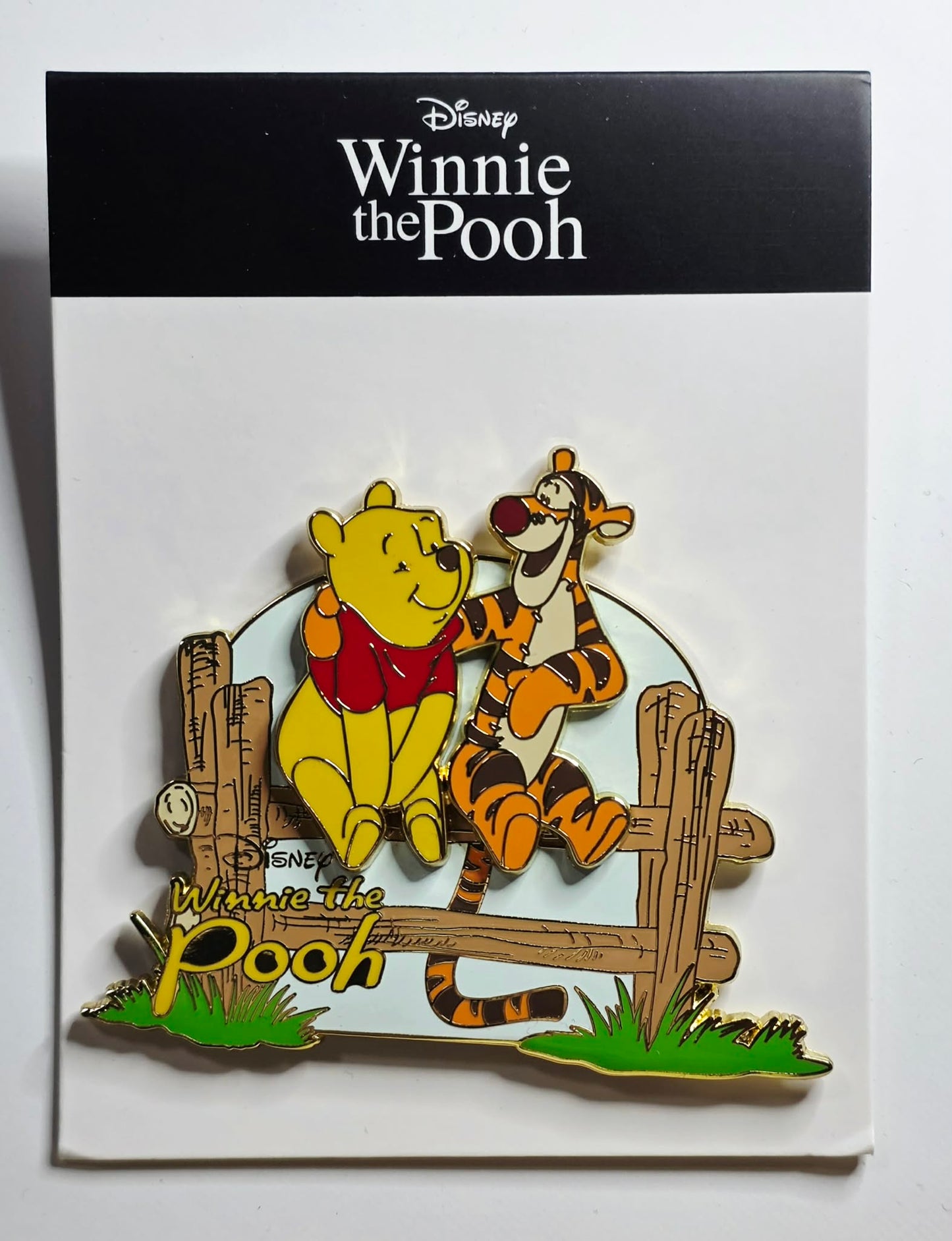 Winnie the Pooh and Tigger sitting together on a wooden fence