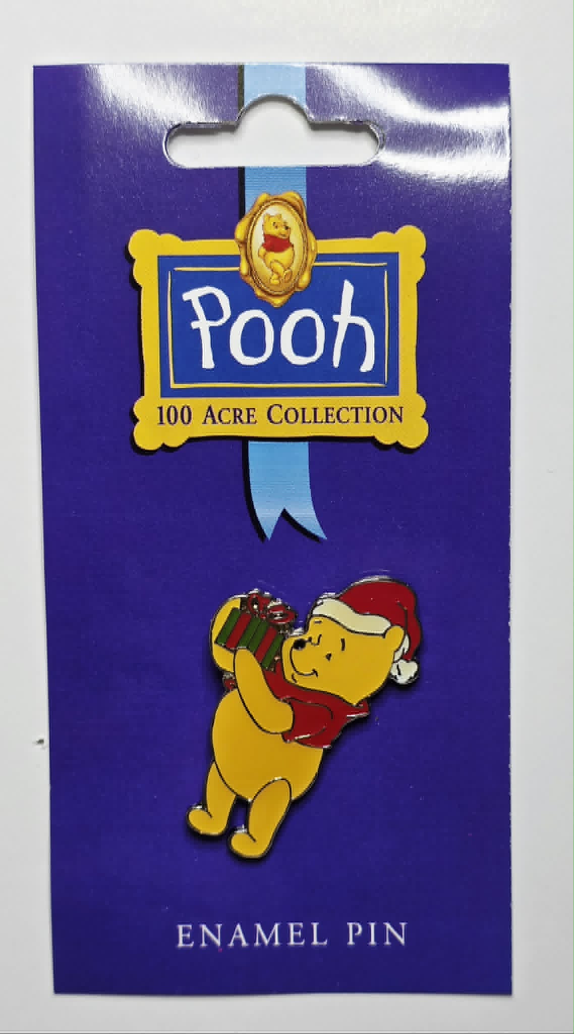 Winnie the Pooh - Winnie the Pooh wearing a Santa hat and holding a Christmas present.