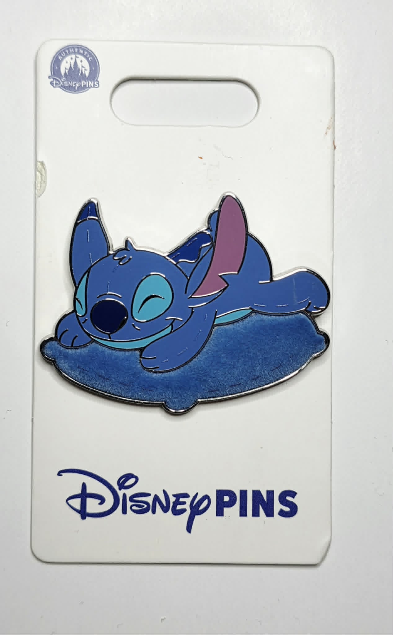 Stitch from Lilo & Stitch sleeping on a flocked blue pillow