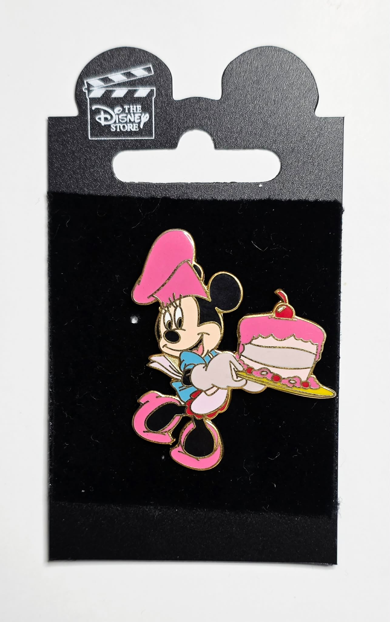 Minnie Mouse dressed as a baker holding a cake